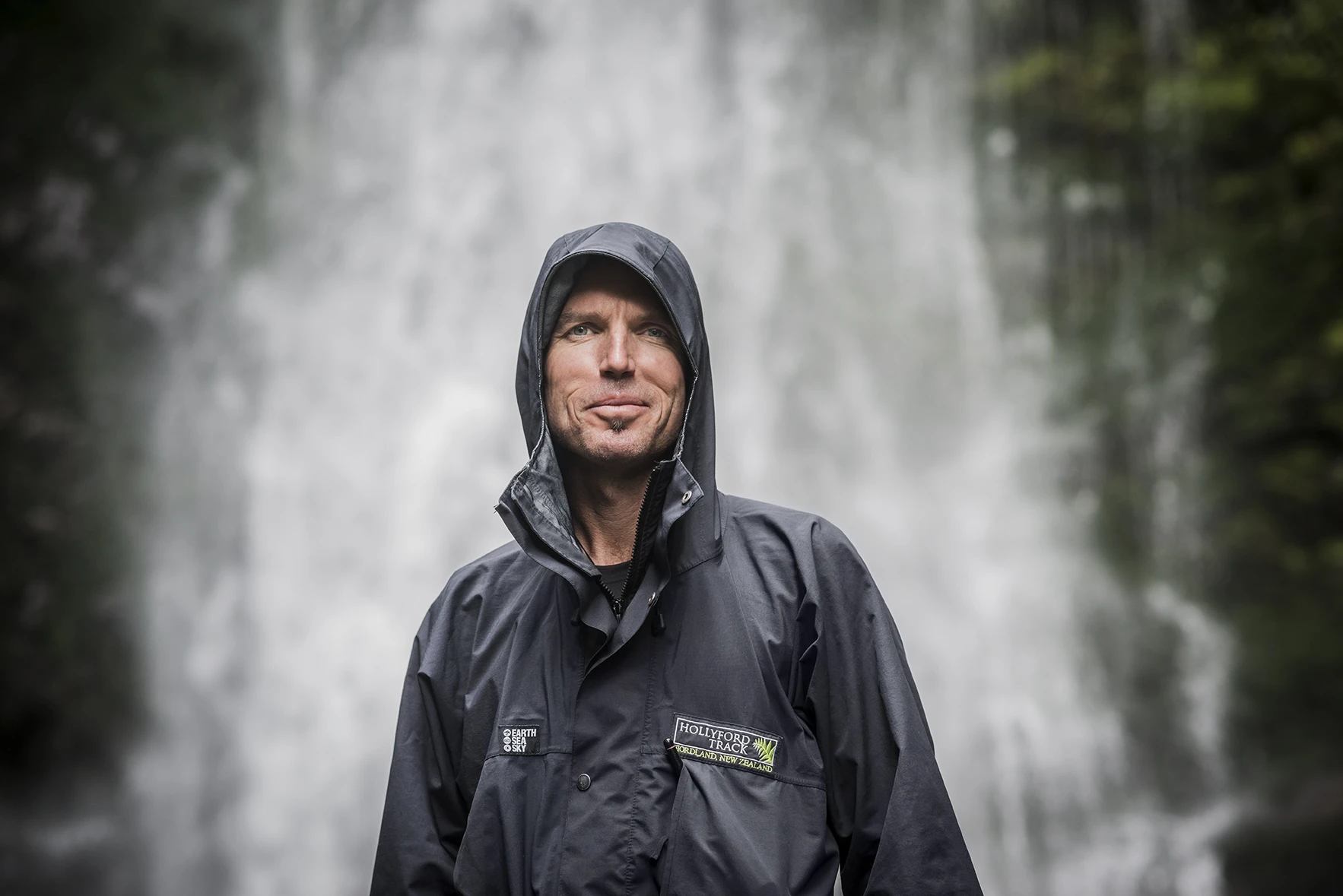 Man standing infront of waterfall